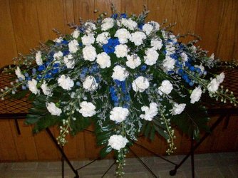 Casket spray of blue delphinium and white carnations from Bunn Flowers & Gifts, local florist in Pittsburg, TX