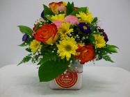 Circle E Candle with fresh flower arrangement on top from Bunn Flowers & Gifts, local florist in Pittsburg, TX